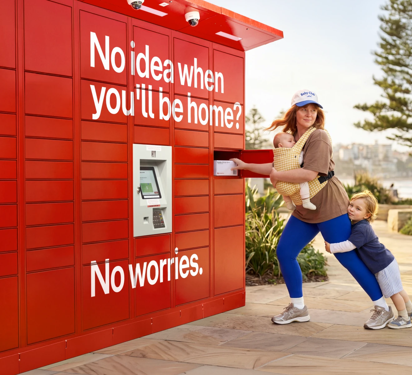 A parent collecting a parcel from a red Parcel Locker